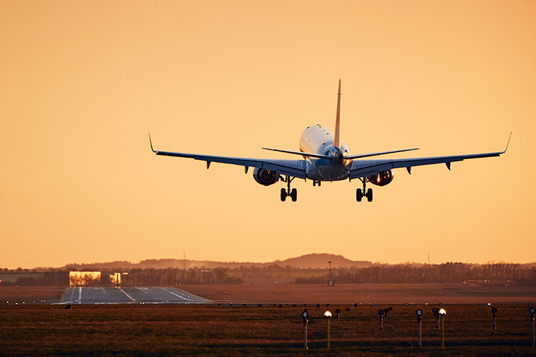 Vliegtuig dat opstijgt van een vliegveld bij zonsondergang